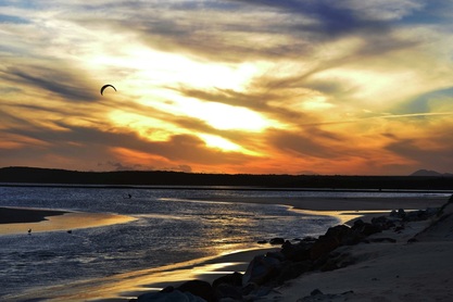 Picture of a kite surfer in front of a sunset at Aston Bay, South Africa.Find more digital photography tips, dslr camera lessons and artistic photo galleries at www.FreePhotoCourse.com.  © 2011, all rights reserved.  