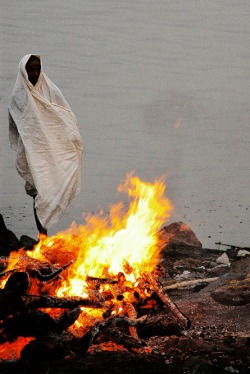 Picture of woman near a fire at the river's edge, Calcutta, India; FreePhotoCourse.com featured photographer profile of Soham Gupta; all rights reserved