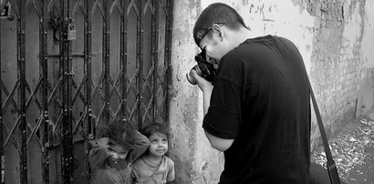 Photograph of Soham Gupta taking pictures of children in Calcutta, India.  Part of the Photographer Profile series from www.FreePhotoCourse.com.  all rights reserved 